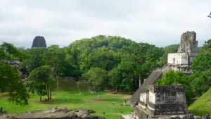 Guatemala, Tikal: Blick von der Acropolis Norte über den Plaza Grande auf die Acropolis Central. Rechts Tempel II und in der linken Bildhälfte aus dem Dschungel aufragend Tempel V